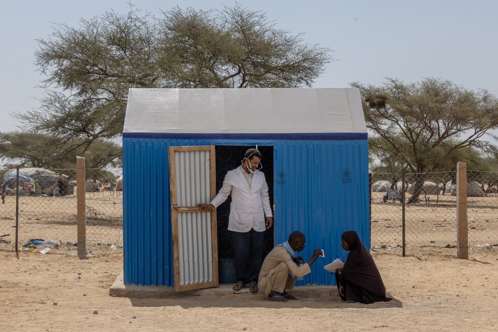 A woman is helped outside a treatment room of a health clinic in Douankara, Mauritania, Sunday, Nov. 7, 2025. (AP Photo/Caitlin Kelly)
