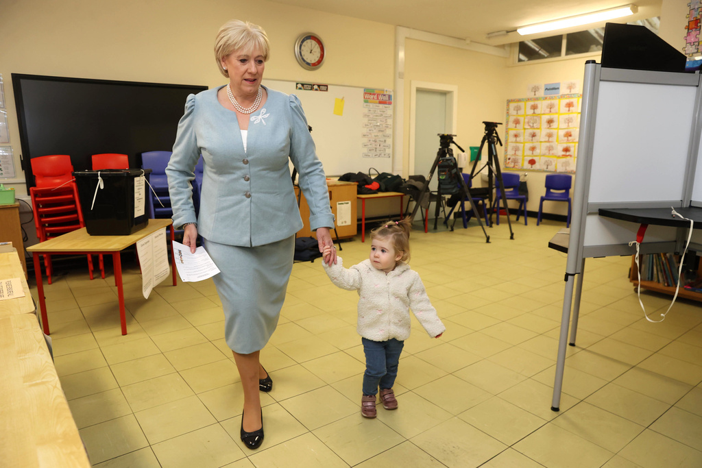 Fine Gael candidate Heather Humphreys casts her vote with the help of her one-year-old grandaughter Charlotte at Killeevan Central National School in Newbliss, Co Monaghan, for the election for the next Irish president, Friday, Oct. 24, 2025. (Liam McBurney/PA Wire/PA via AP)