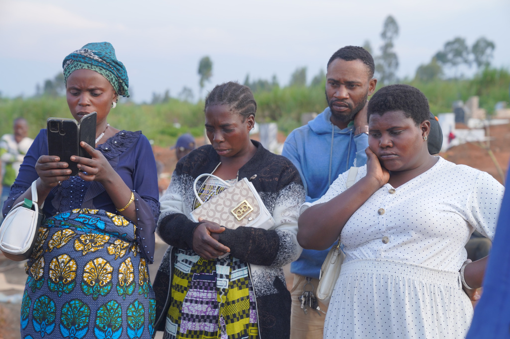 Family and friends gather for a burial service for 3-year-old Mave Mercienne, who died of Ebola, in Bunia, Ituri province, eastern Congo, Tuesday, Aug. 18, 2026. (AP Photo/Dieudonne Dirole)