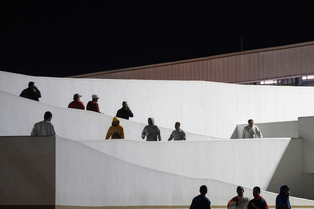 Migrants walk into Mexico after being deported from the United States at El Chaparral pedestrian border bridge in Tijuana, Mexico, Jan. 21, 2025. (AP Photo/Felix Marquez, File)