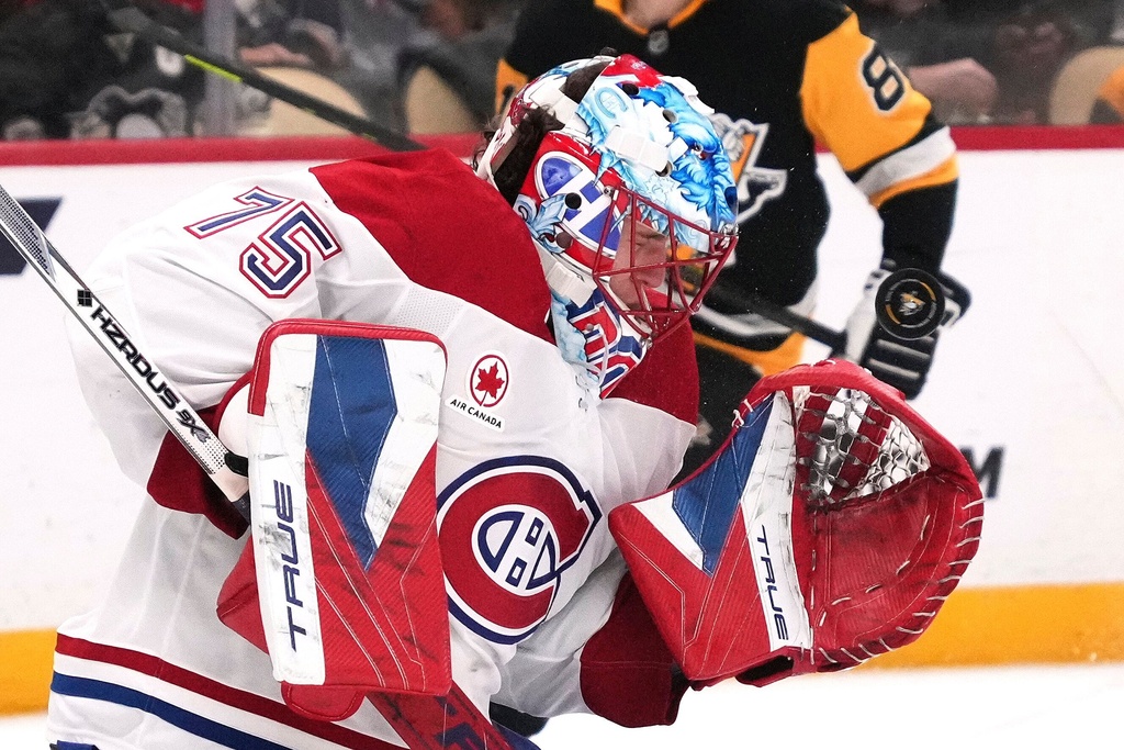 Montréal Canadiens goaltender Jakub Dobes takes a shot off his mask during the second period of an NHL hockey game against the Pittsburgh Penguins in Pittsburgh, Sunday, Dec. 21, 2025. (AP Photo/Gene J. Puskar)