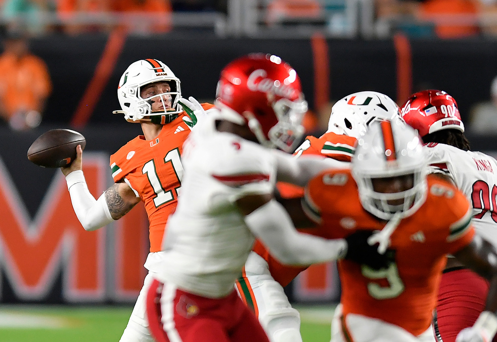 Miami quarterback Carson Beck (11) throws the ball during the first half of an NCAA college football game against Louisville, Friday, Oct. 17, 2025, in Miami Gardens, Fla. (AP Photo/Michael Laughlin)