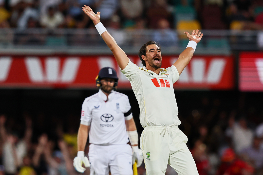 Australia's Mitchell Starc appeals successfully for the wicket of England's Joe Root, left, during the second Ashes cricket test match between Australia and England in Brisbane, Saturday, Dec. 6, 2025.. (AP Photo/Tertius Pickard)