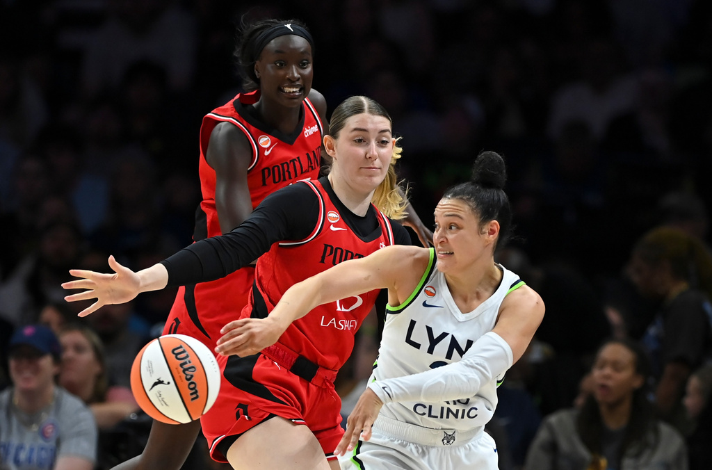 Minnesota Lynx guard Kayla McBride (21) passes the ball as she's defended by Portland Fire center Luisa Geiselsoder (15) in the first quarter of a WNBA basketball game on Saturday, July 18, 2026, in Minneapolis, Minn. (Aaron Lavinsky/Minnesota Star Tribune via AP)