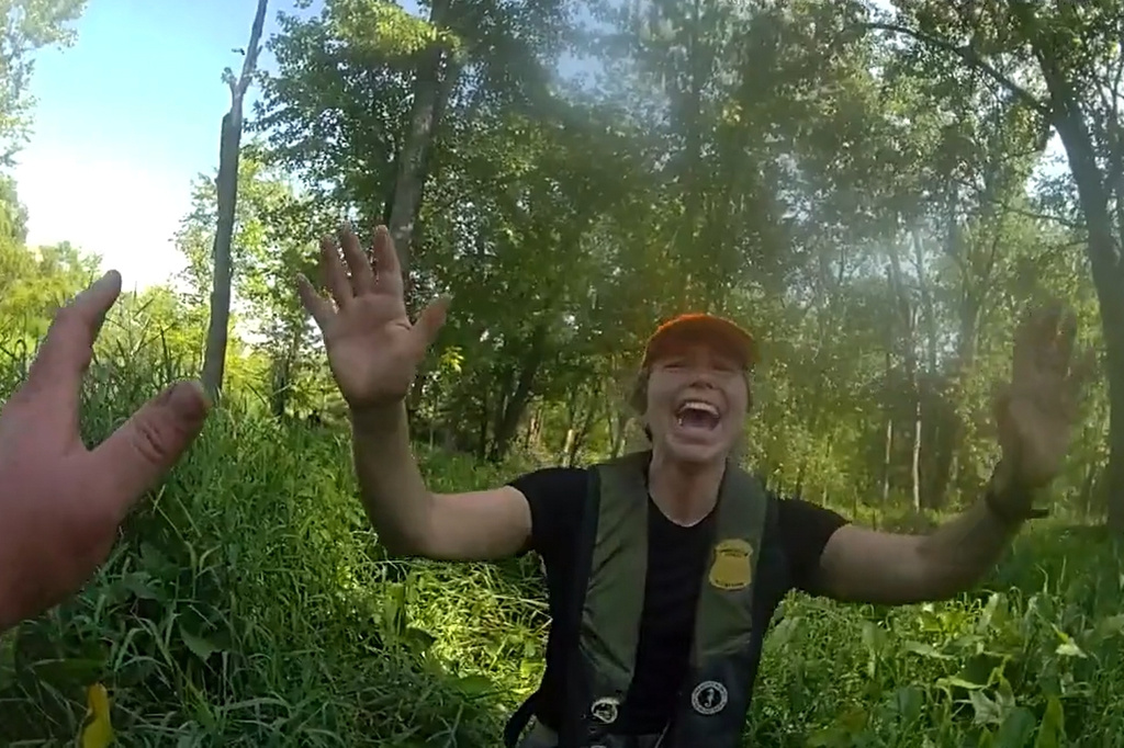 This image made from video provided by the Michigan Department of Natural Resources shows conservation officer Anna Cullen celebrating on Friday, Aug. 7, 2026, in Twin Lake, Mich., as a search and rescue team found two women and a child who had been missing after taking a river tubing trip. (