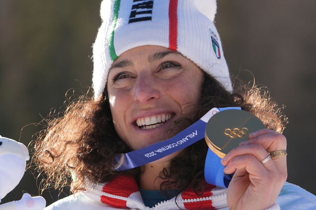 Italy's Federica Brignone shows her gold medal in an alpine ski, women's giant slalom race, at the 2026 Winter Olympics, in Cortina d'Ampezzo, Italy, Sunday, Feb. 15, 2026. (AP Photo/Jacquelyn Martin)