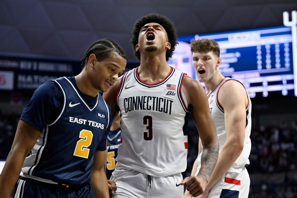 UConn's Jaylin Stewart, center, reacts after making a basket while fouled as East Texas A&M's Evan Phelps, left, and UConn's Eric Reibe, right, look on in the first half of an NCAA college basketball game, Friday, Dec. 5, 2025, in Storrs, Conn. (AP Photo/Jessica Hill)