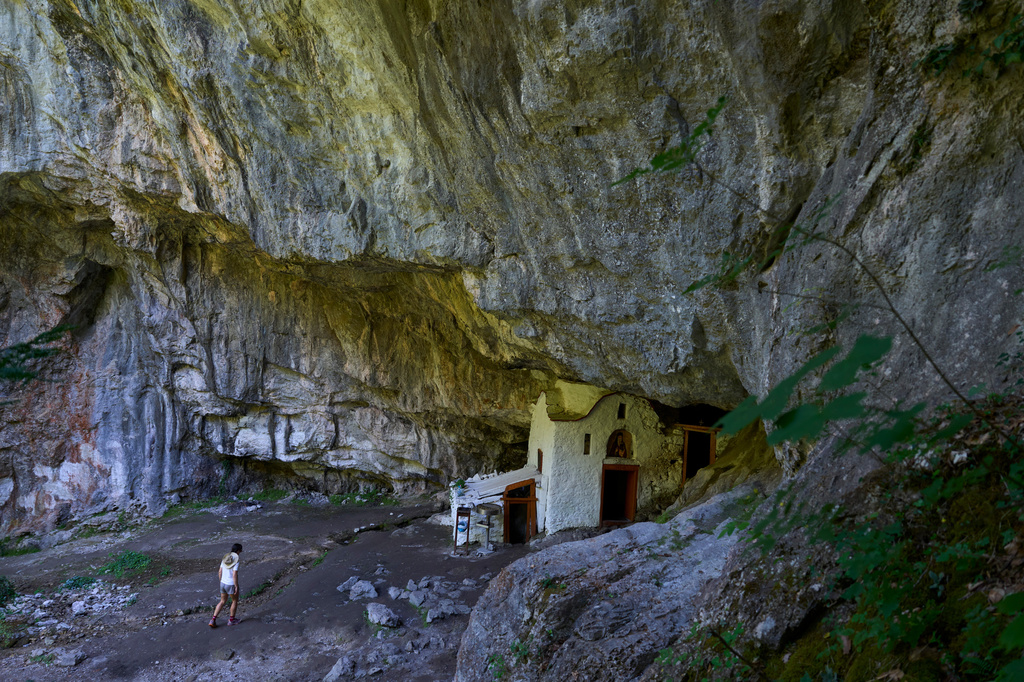 A visitor approaches a chapel at the Holy Cave of St. Dionysios in the Enipeas Gorge on Mount Olympus in northern Greece, Tuesday, July 14, 2026. (AP Photo/Petros Giannakouris)
