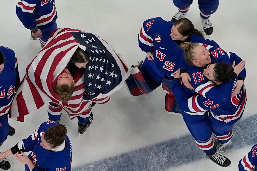 Team United States players celebrate after beating Canada 2-1 in overtime in the women's ice hockey gold medal game at the 2026 Winter Olympics, in Milan, Italy, Thursday, Feb. 19, 2026. (AP Photo/David J. Phillip)