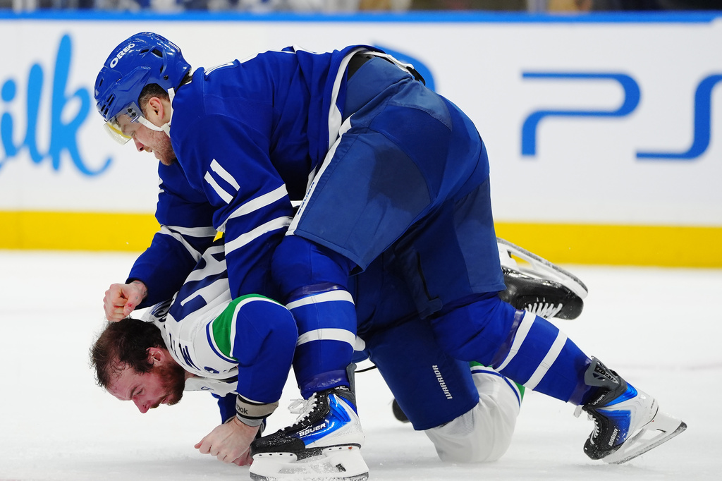 Toronto Maple Leafs' Max Domi (11) and Vancouver Canucks' Marcus Pettersson, bottom, fight during second-period NHL hockey game action in Toronto, Saturday, Jan. 10, 2026. (Frank Gunn/The Canadian Press via AP)