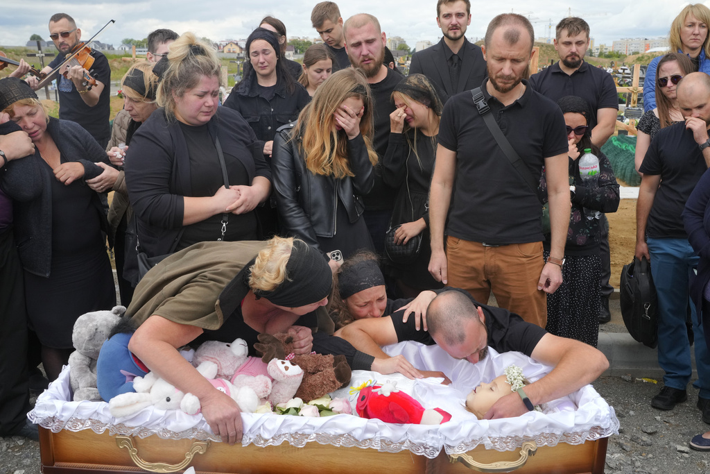 FILE - Relatives and friends attend the funeral ceremony for Liza, 4-year-old girl killed by Russian attack, in Vinnytsia, Ukraine, July 17, 2022. (AP Photo/Efrem Lukatsky, File)