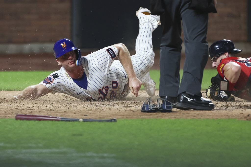 New York Mets first base Pete Alonso (20) is out at home plate as he slides past Atlanta Braves catcher Sean Murphy during the fourth inning of a baseball game, Wednesday, Aug. 13, 2025, in New York. (AP Photo/Heather Khalifa)