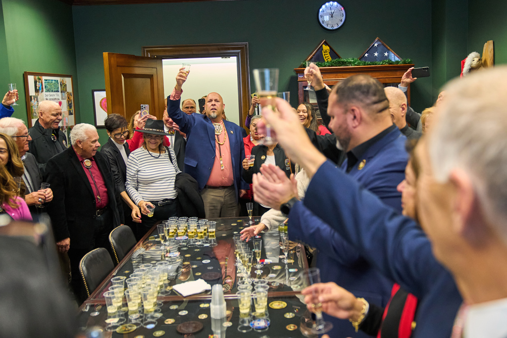 John Lowery, N.C. State Rep. and Chairman of the Lumbee Tribe of N.C., leads a toast to Sen. Thom Tillis, R-N.C., center, front right, as members of the Lumbee Tribe of North Carolina, celebrate the passage of a bill granting their people federal recognition, on Capitol Hill, in Washington, Wednesday, Dec. 17, 2025. (AP Photo/Jacquelyn Martin)