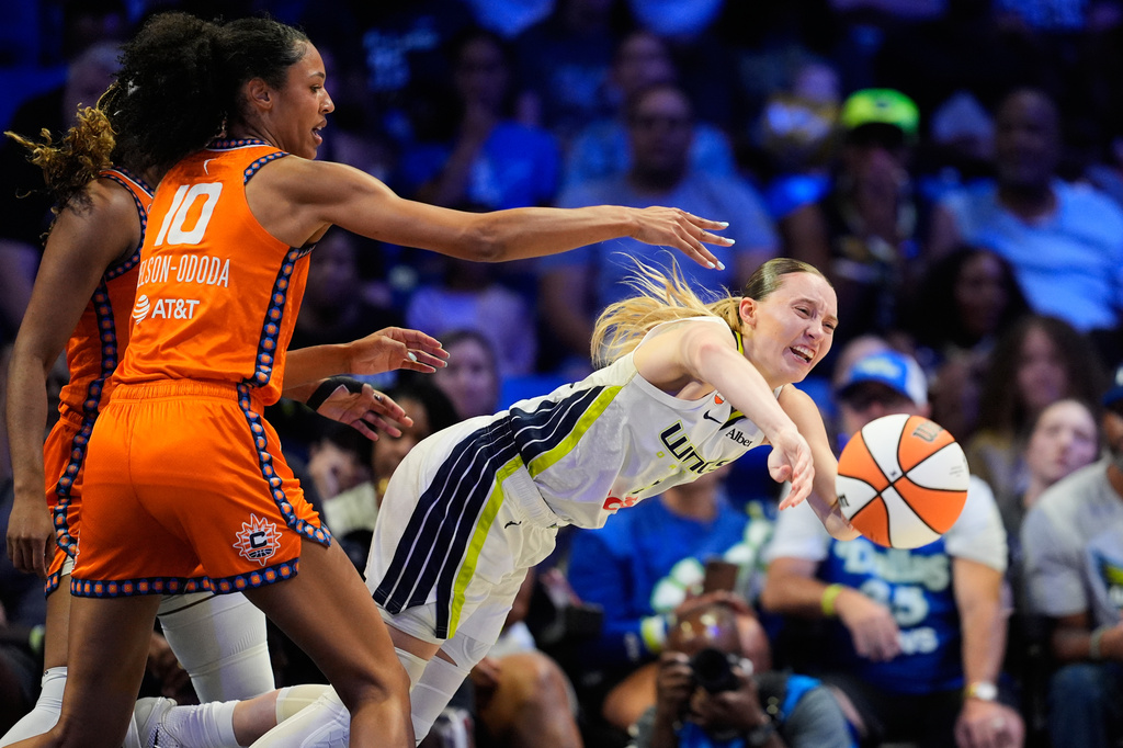 Dallas Wings guard Paige Bueckers, right, makes a pas as Connecticut Sun's Olivia Nelson-Ododa (10) defends during the first half of a WNBA basketball game in Arlington, Texas, Sunday, Aug. 2, 2026. (AP Photo/Tony Gutierrez)