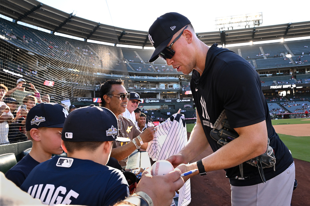 New York Yankees' Aaron Judge, right, gives autographs to fans before a baseball game against the Los Angeles Angels, Monday}, Aug. 31, 2026, in Anaheim, Calif. (AP Photo/Wally Skalij)