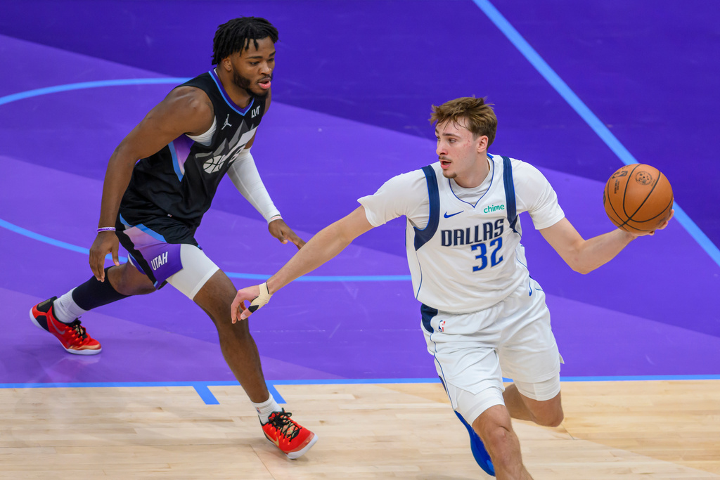 Dallas Mavericks forward Cooper Flagg, right, looks to pass the ball while guarded by Utah Jazz guard Isaiah Collier, left, during the first half of an NBA basketball game, Monday, Dec. 15, 2025, in Salt Lake City. (AP Photo/Tyler Tate)
