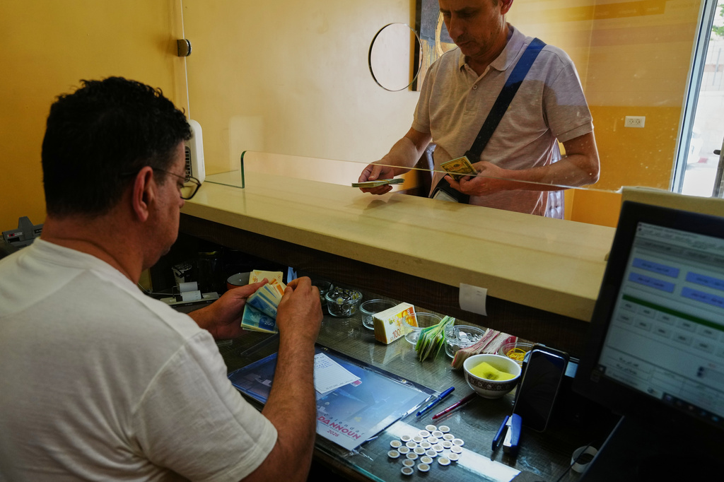 A currency exchange employee counts Israeli Shekels at a bureau in the West Bank city of Bethlehem, Tuesday, July 7, 2026. (AP Photo/Mahmoud Illean)