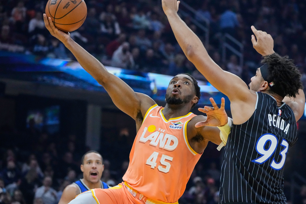 Cleveland Cavaliers guard Donovan Mitchell (45) goes to the basket past Orlando Magic forward Noah Penda (93) in the first half of an NBA basketball game in Cleveland, Monday, Jan. 26, 2026. (AP Photo/Sue Ogrocki)