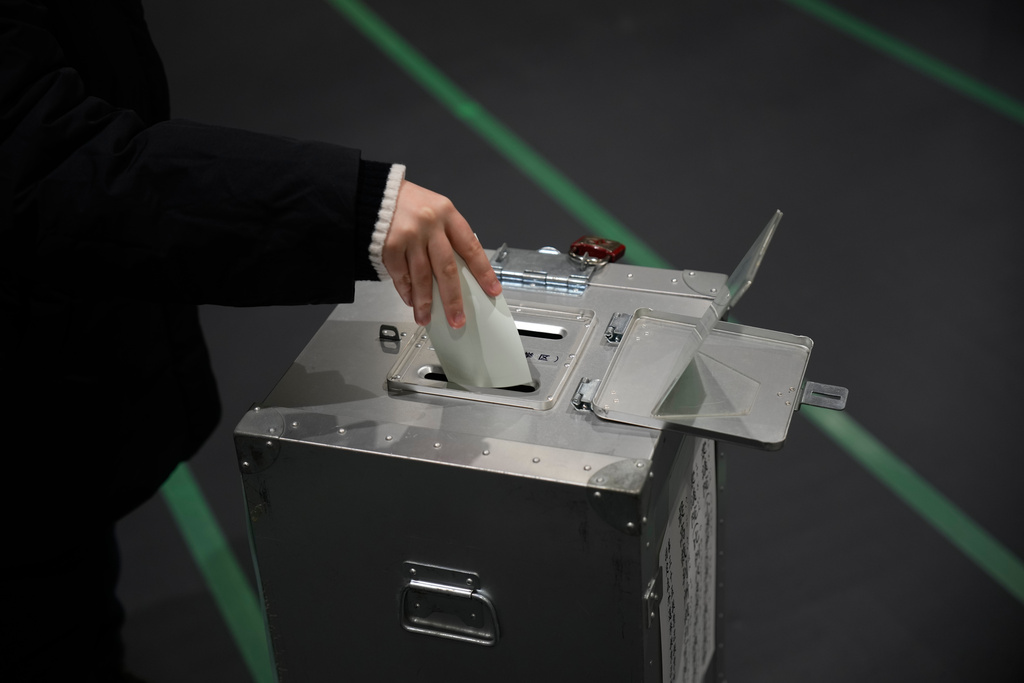 A voter fills in a ballot in the lower house election at a polling station Sunday, Feb. 8, 2026, in Tokyo. (AP Photo/Louise Delmotte)