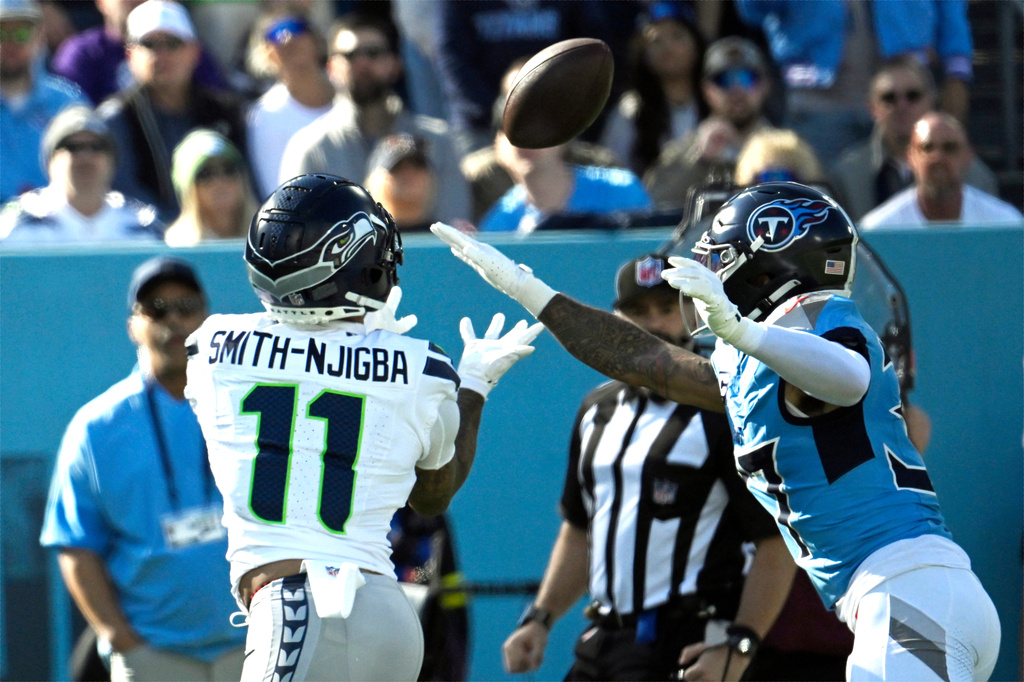 Seattle Seahawks wide receiver Jaxon Smith-Njigba (11) catches a touchdown pass ahead of Tennessee Titans safety Amani Hooker (37) during the first half of an NFL football game Sunday, Nov. 23, 2025, in Nashville, Tenn. (AP Photo/John Amis)