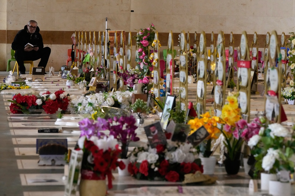 A man prays over the graves of Hezbollah fighters killed, at Al-Hawraa Zaynab Cemetery during Eid al-Fitr in Dahiyeh, Beirut's southern suburbs, Lebanon, Friday, March 20, 2026. (AP Photo/Hassan Ammar)