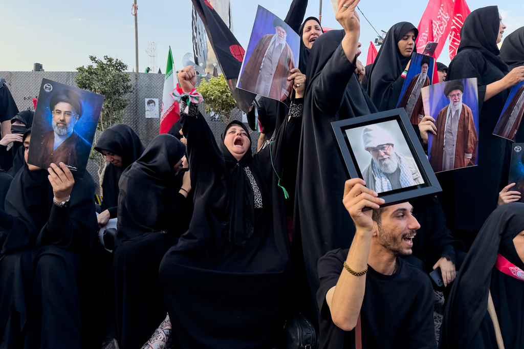 Mourners hold a portrait of Iran's new Supreme Leader, Mojtaba Khamenei, left, and portraits of the slain Iranian Supreme Leader Ayatollah Ali Khamenei while waiting in Islamic Revolution Square for his funeral procession in Tehran, Iran, Monday, July 6, 2026. (AP Photo/Altaf Qadri)