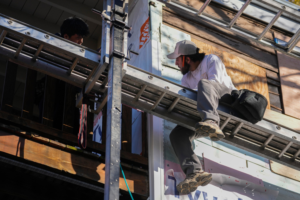 Uriel Villegas, top left, and his brother Julian work at the construction site where their older brother was taken by federal immigration agents in October, Tuesday, Nov. 18, 2025, in Chicago. (AP Photo/Erin Hooley)