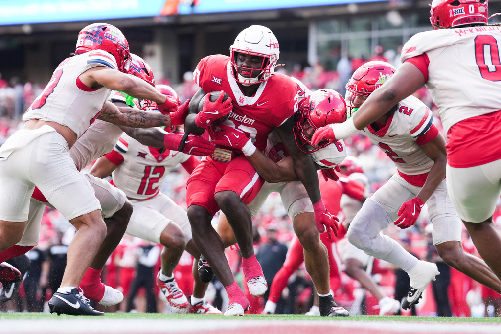 Houston running back J'Marion Burnette (20) is tackled by Arizona linebacker Taye Brown (6) during the first half of an NCAA college football game, Saturday, Oct. 18, 2025, in Houston. (Jason Fochtman/Houston Chronicle via AP)