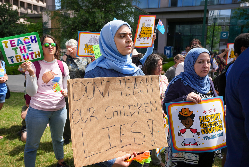Aasya Peera of Pflugerville holds a sign reading "Don't teach our children lies!" during a rally on the Capitol Mall outside the Barbara Jordan State Office Building, where the State Board of Education meets, Tuesday, April 7, 2026, in Austin, Texas. (Jay Janner/Austin American-Statesman via AP)