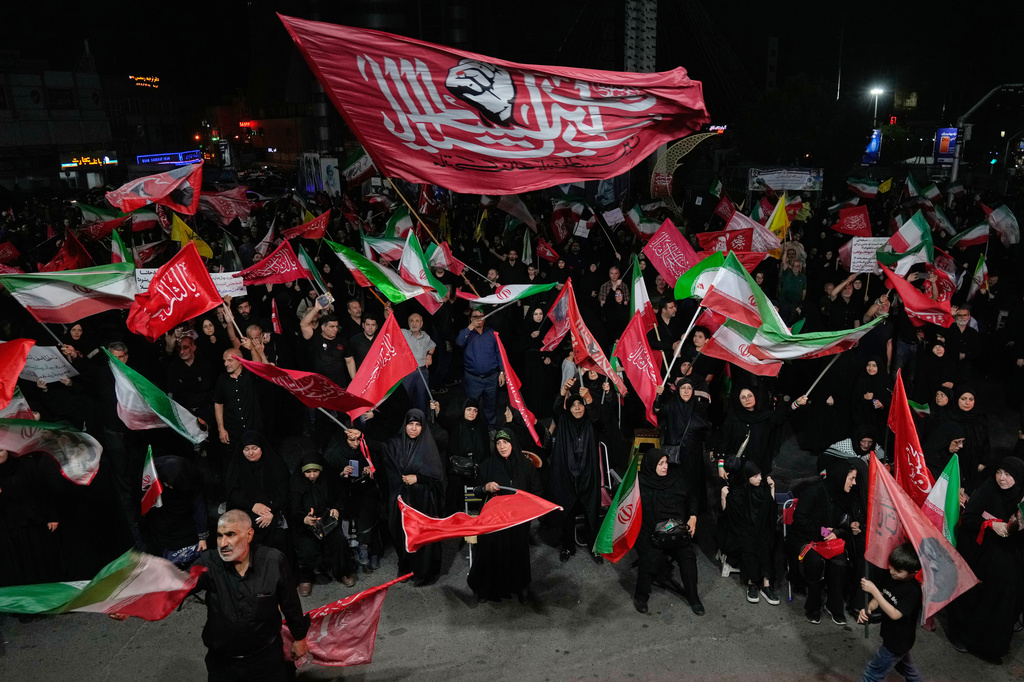 Iranian pro-government demonstrators wave flags in a gathering at a square in Tehran, Iran, Tuesday, Aug. 11, 2026. (AP Photo/Vahid Salemi)