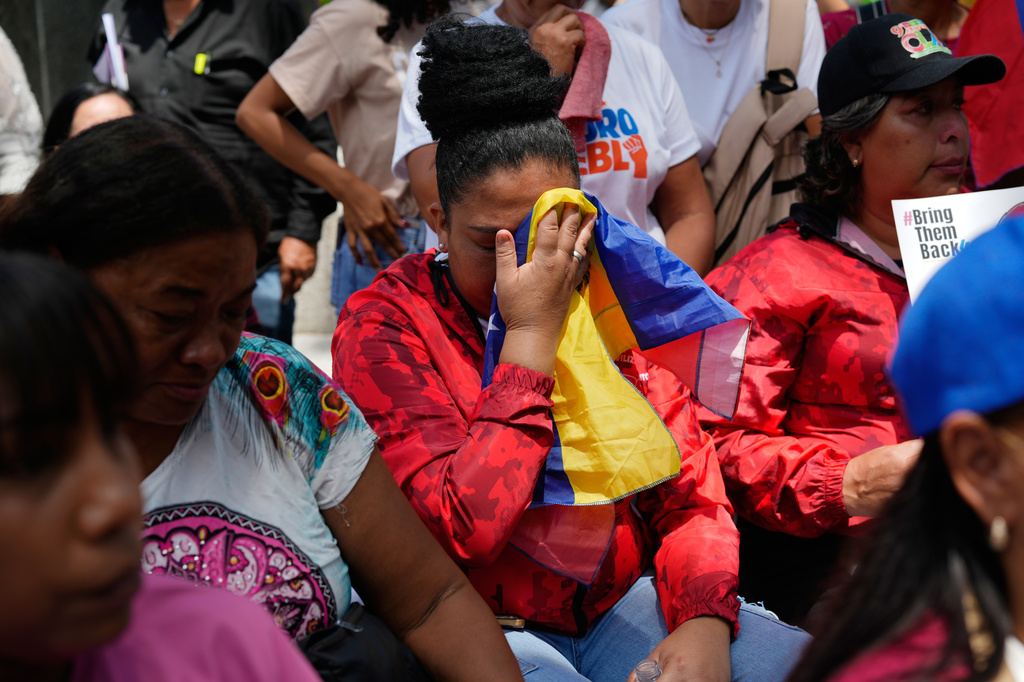 People react during a government-organized event to watch former President Nicolas Maduro and first lady Cilia Flores appear in a New York court on a screen in Caracas, Venezuela, Thursday, March 26, 2026. (AP Photo/Ariana Cubillos)