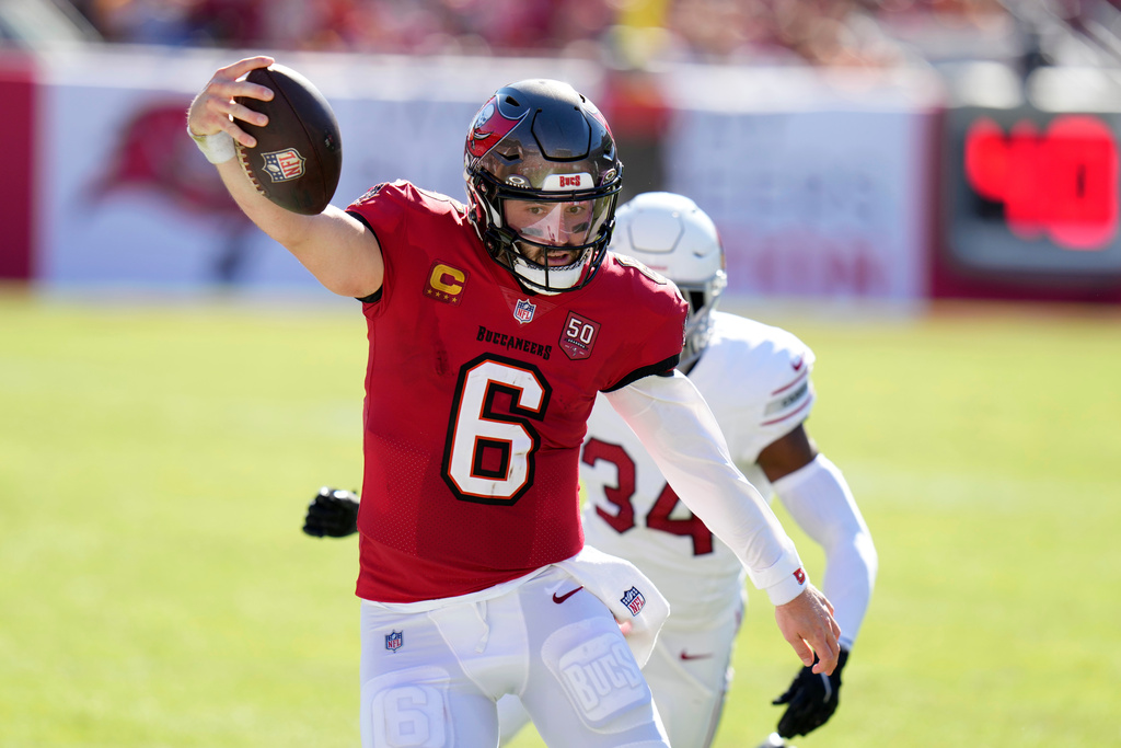 Tampa Bay Buccaneers quarterback Baker Mayfield (6) runs past Arizona Cardinals safety Jalen Thompson (34) during the first half of an NFL football game Sunday, Nov. 30, 2025, in Tampa, Fla. (AP Photo/Chris O'Meara)