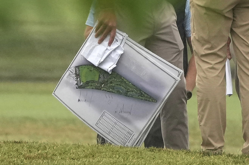 A person carries blueprints as President Donald Trump tours the East Potomac Park golf course, Sunday, June 28, 2026, in Washington. (AP Photo/Mark Schiefelbein)
