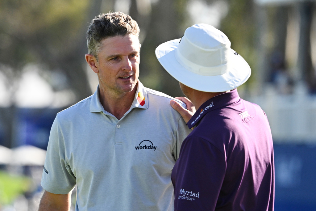 Justin Rose, of England, left, talks to Joel Dahmen on the 18th green after winning the Farmers Insurance Open golf tournament Sunday, Feb. 1, 2026, at Torrey Pines in San Diego. (AP Photo/Denis Poroy)