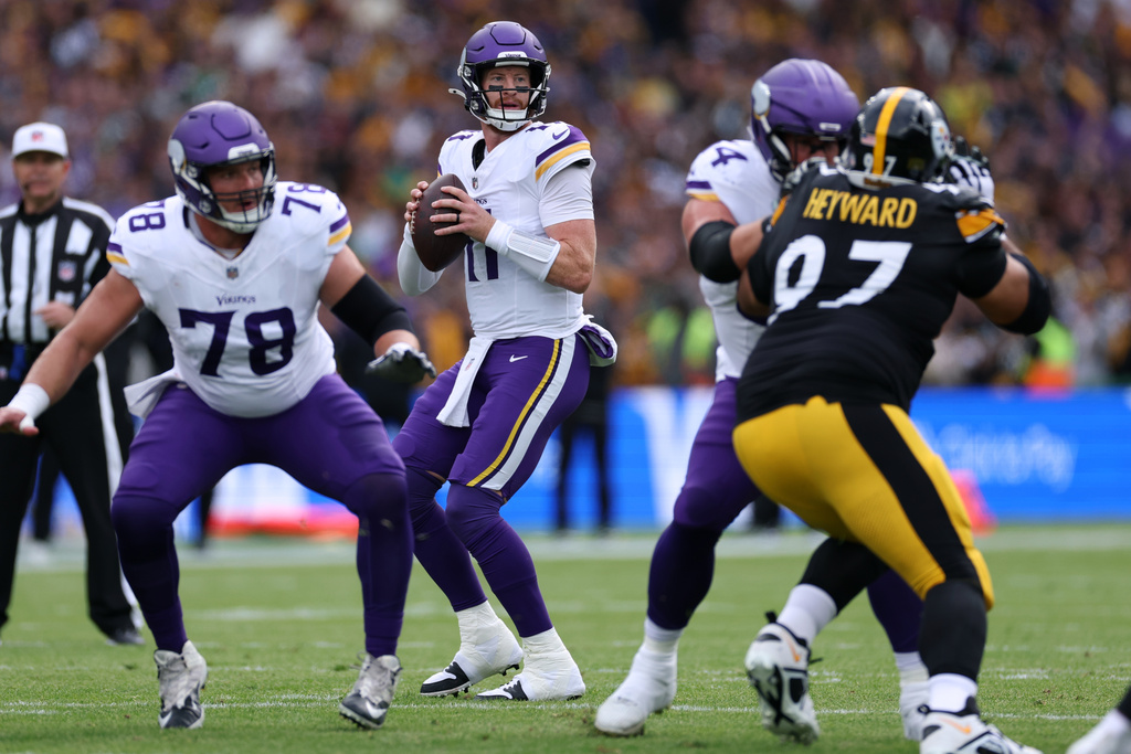 Minnesota Vikings quarterback Carson Wentz (11) controls the ball during the NFL football game between Minnesota Vikings and Pittsburgh Steelers at Croke Park stadium in Dublin, Sunday, Sept. 28, 2025.(AP Photo/Ian Walton)