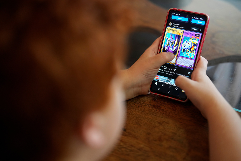 A boy uses a social media platform in Brasilia, Brazil, Thursday, March 19, 2026. A new law regulating children’s use of social media took effect this week, requiring users under 16 to link their accounts to a legal guardian. (AP Photo/Eraldo Peres)