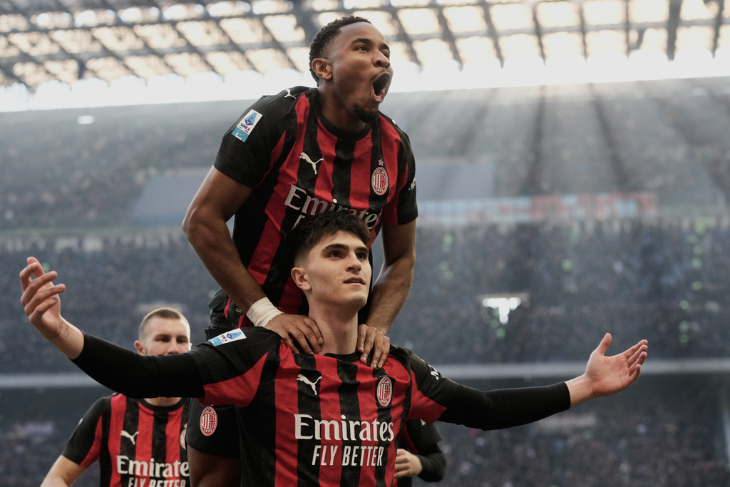AC Milan's Davide Bartesaghi celebrates with AC Milan's Christopher Nkunku, top, after scoring his side's second goal during the Serie A soccer match between AC Milan and Sassuolo, in Milan, Italy, Sunday, Dec. 14, 2025. (AP Photo/Luca Bruno)