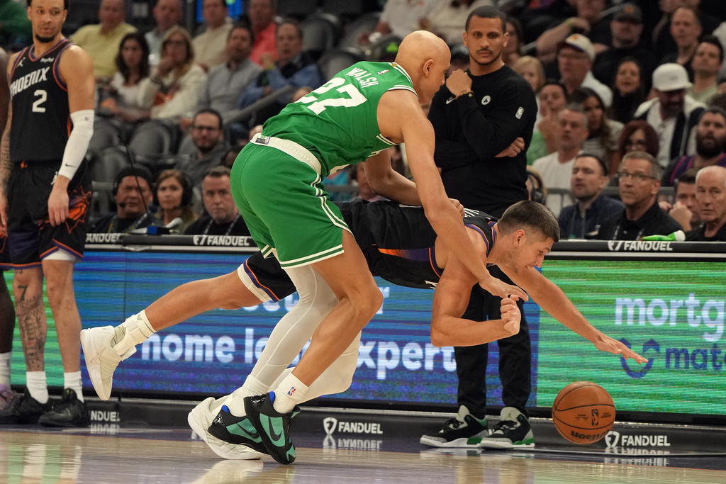 Boston Celtics guard Jordan Walsh (27) fouls Phoenix Suns guard Grayson Allen during the first half of an NBA basketball game, Tuesday, Feb. 24, 2026, in Phoenix. (AP Photo/Rick Scuteri)