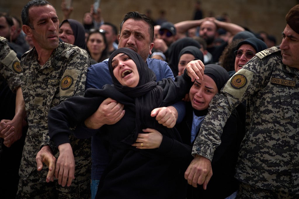Mourners react during the funeral of 13 state security officers who were killed the previous day in an Israeli strike in Lebanon's coastal city of Sidon, Saturday, April 11, 2026. (AP Photo/Emilio Morenatti)