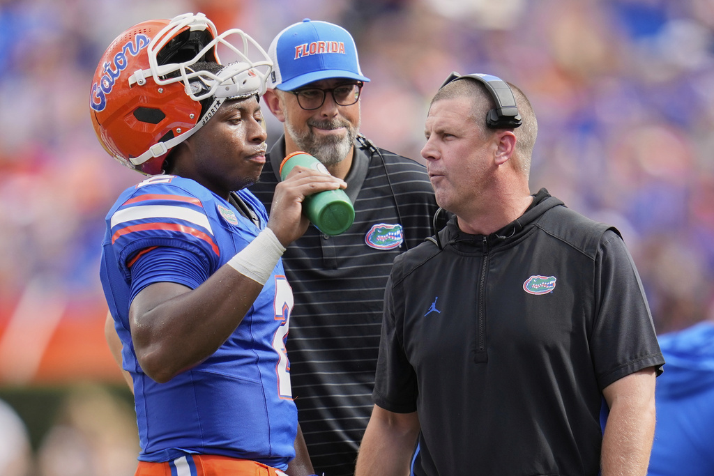 Florida head coach Billy Napier, right, talks with quarterback DJ Lagway during time out in the first half of an NCAA college football game against South Florida, Saturday, Sept. 6, 2025, in Gainesville, Fla. (AP Photo/John Raoux)