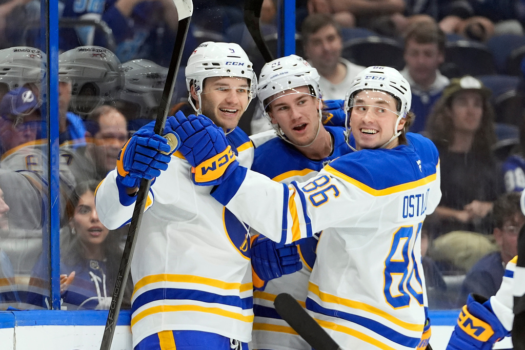 Buffalo Sabres center Josh Norris (9) celebrates his goal against the Tampa Bay Lightning with right wing Josh Doan, and center Noah Ostlund (86) during the first period of an NHL hockey game Saturday, Feb. 28, 2026, in Tampa, Fla. (AP Photo/Chris O'Meara)