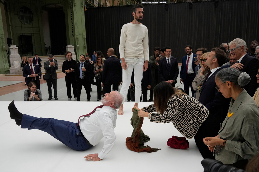 FILE - Brazil's President Luiz Inacio Lula da Silva spontaneously shows off an acrobatic pose inspired by the Ernesto Neto exhibition, during his visit to the Grand Palais museum in Paris, June 6, 2025. (AP Photo/Michel Euler, File)