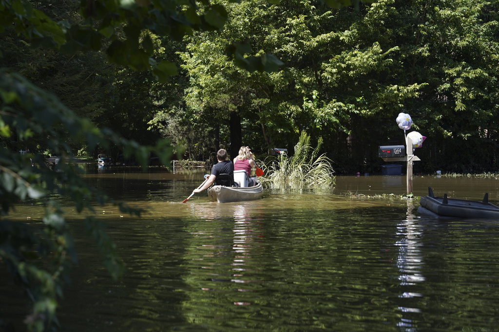 Residents paddle through a flooded neighborhood in a kayak in Indianapolis, Sunday, Aug. 16, 2026. (AP Photo/Obed Lamy)