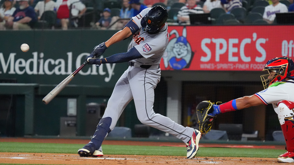 Detroit Tigers' Riley Greene, left, hits a home run in front of Texas Rangers catcher Kyle Higashioka, right, during the first inning of a baseball game, Saturday, July 4, 2026, in Arlington, Texas. (AP Photo/LM Otero)