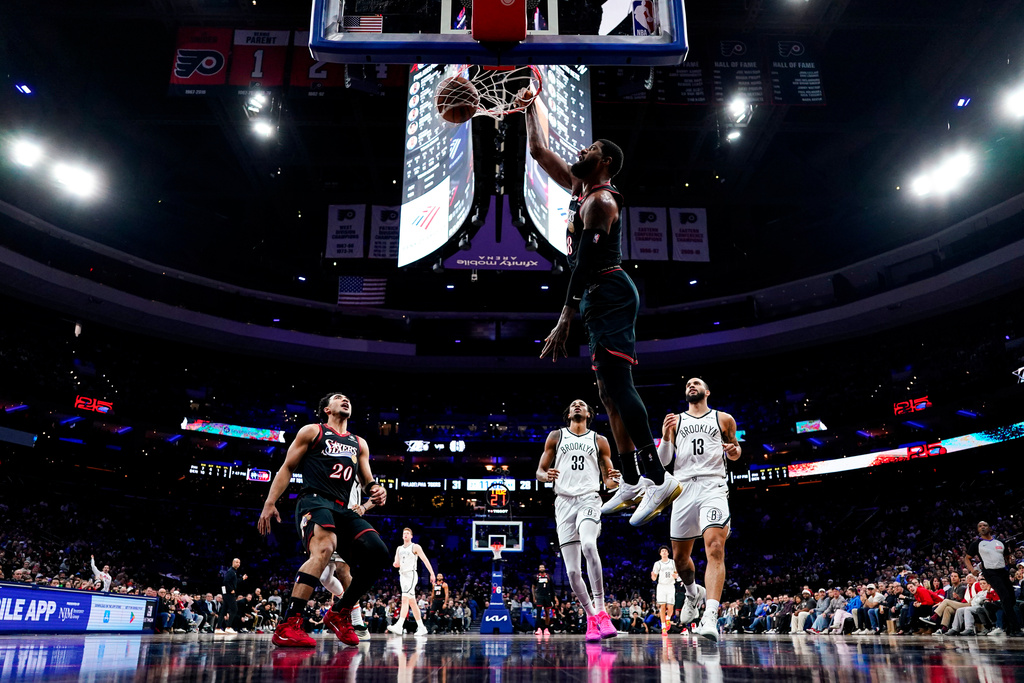 Philadelphia 76ers' Paul George, second from right, dunks the ball during the first half of an NBA basketball game against the Brooklyn Nets, Tuesday, Dec. 23, 2025, in Philadelphia. (AP Photo/Chris Szagola)