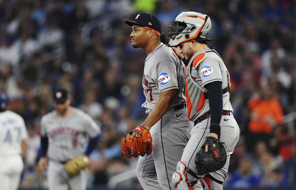 Houston Astros pitcher Luis Garcia (left) is visited by teammates on the mound before leaving the game against the Toronto Blue Jays during second inning MLB baseball action in Toronto on Tuesday, Sept. 9, 2025. (Nathan Denette/The Canadian Press via AP)