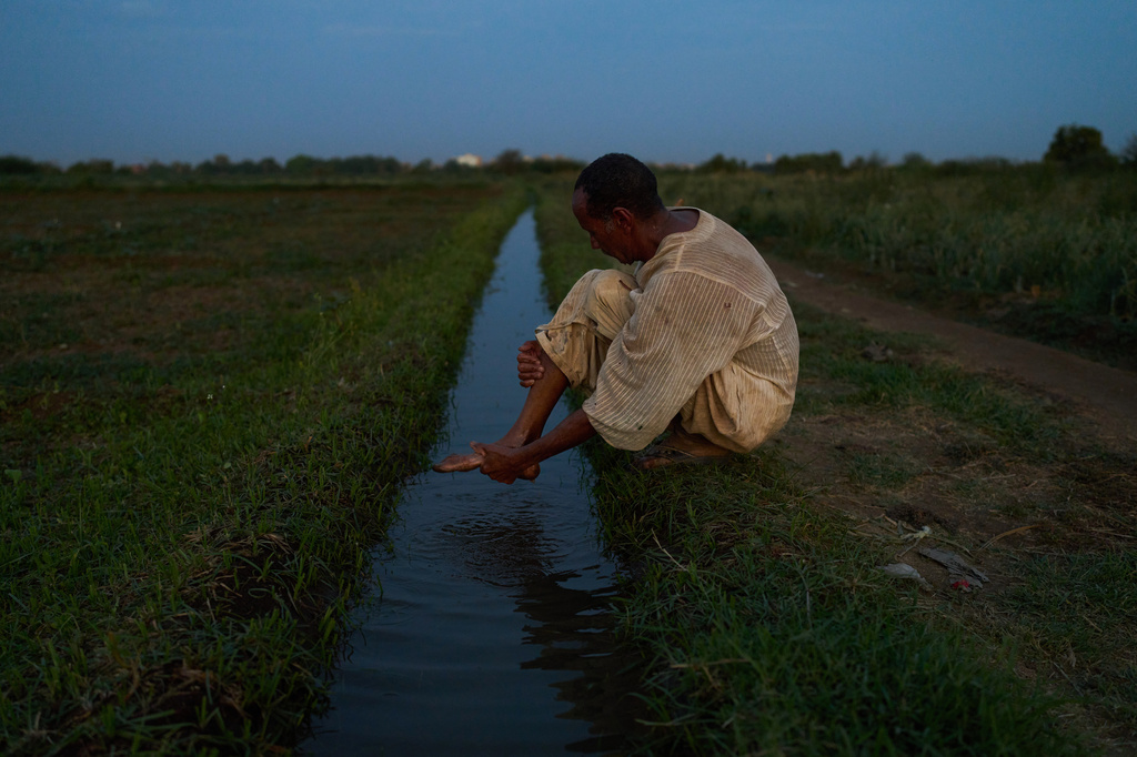 Farmer Omer al Hassan washes his feet before Muslim prayer in Omdurman, Sudan, Saturday, April 25, 2026. (AP Photo/Bernat Armangue)
