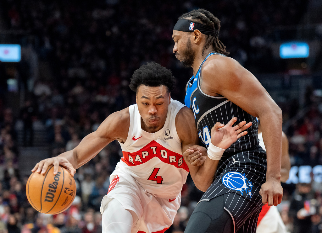 Toronto Raptors forward Scottie Barnes (4) drives against Orlando Magic center Wendell Carter Jr., right, during first-half NBA basketball game action in Toronto, Monday Dec. 29, 2025. (Frank Gunn/The Canadian Press via AP)