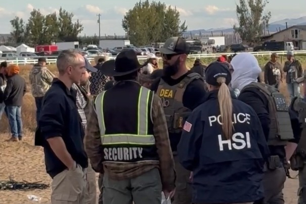 This image from video provided by Nikki Ramirez-Smith shows officers from various law enforcement agencies during a raid at La Catedral Arena horse race track in Wilder, Idaho, on Oct. 19, 2025. (Nikki Ramirez-Smith via AP)