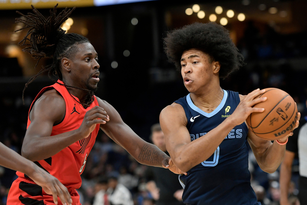 Memphis Grizzlies forward Jaylen Wells, right, handles the ball against Portland Trail Blazers guard Jrue Holiday in the first half of an NBA basketball game, Wednesday, March 4, 2026, in Memphis, Tenn. (AP Photo/Brandon Dill)
